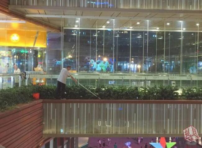 保洁站在悬空玻璃外沿拖地
